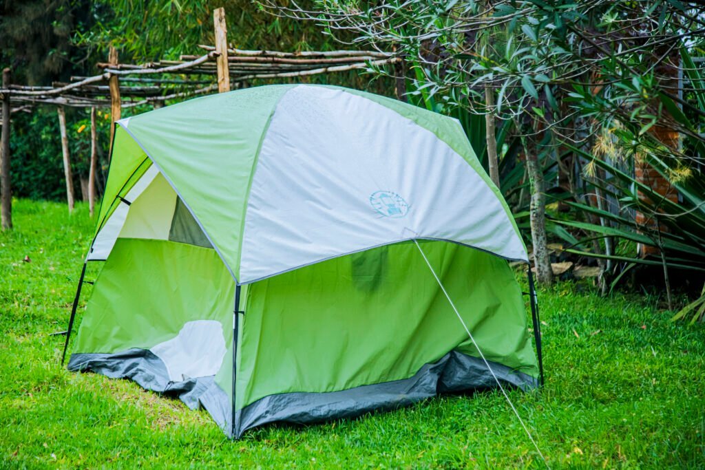 Camping tent beside a woven wooden fence in a garden